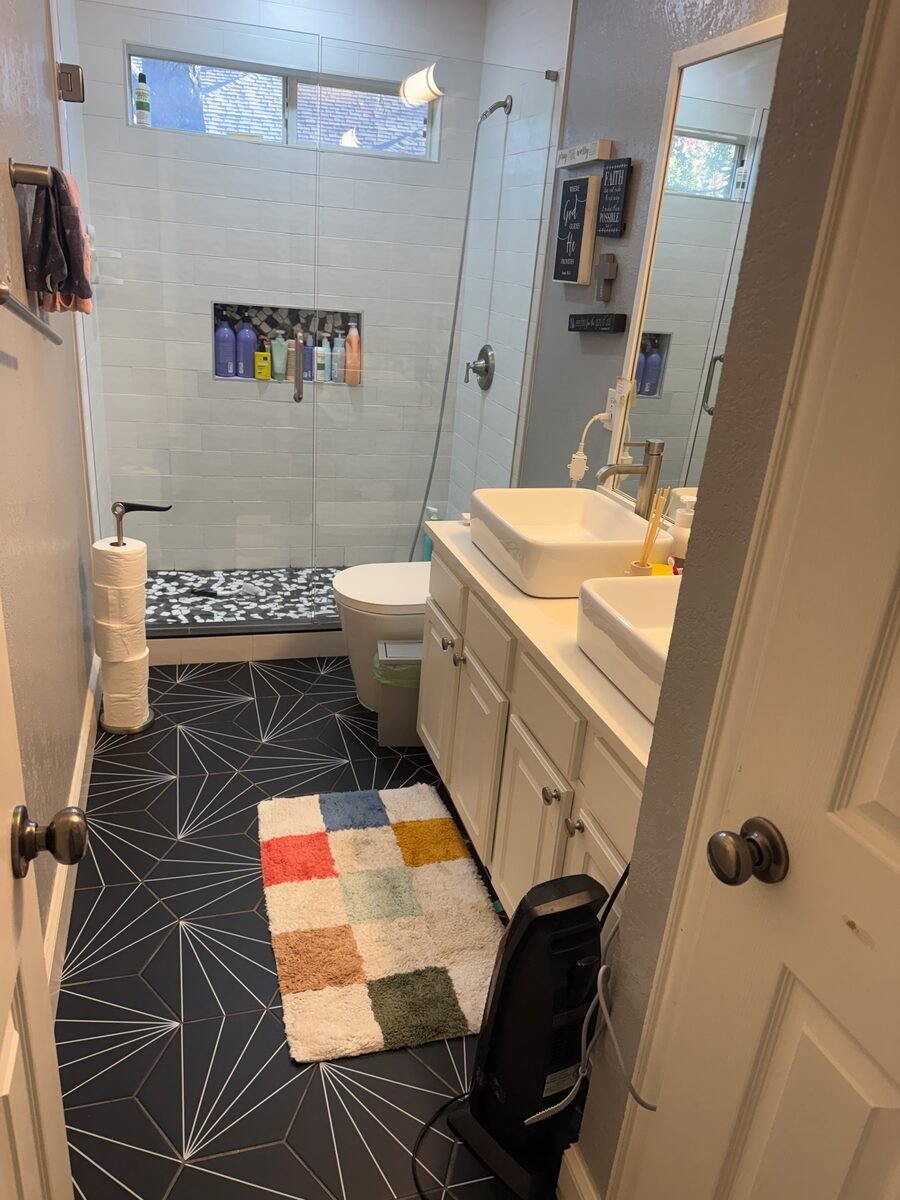 A bathroom with the shower, basin and patterned floor cleaned