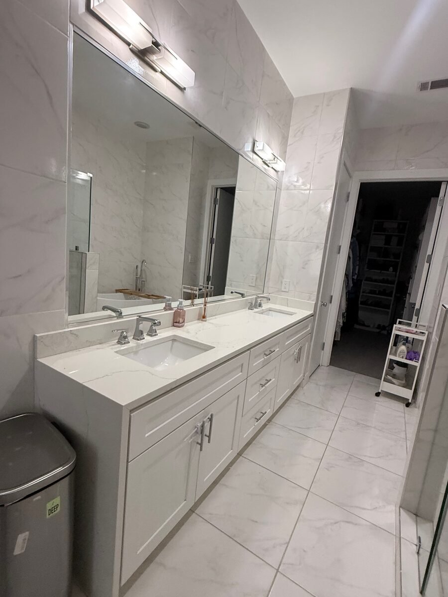 A long vanity with the marble top and mirror cleaned