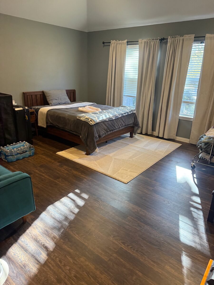 a made bed and a freshly cleaned hardwood floor in a Coppell home cleaned by SusyQ’s Cleaning