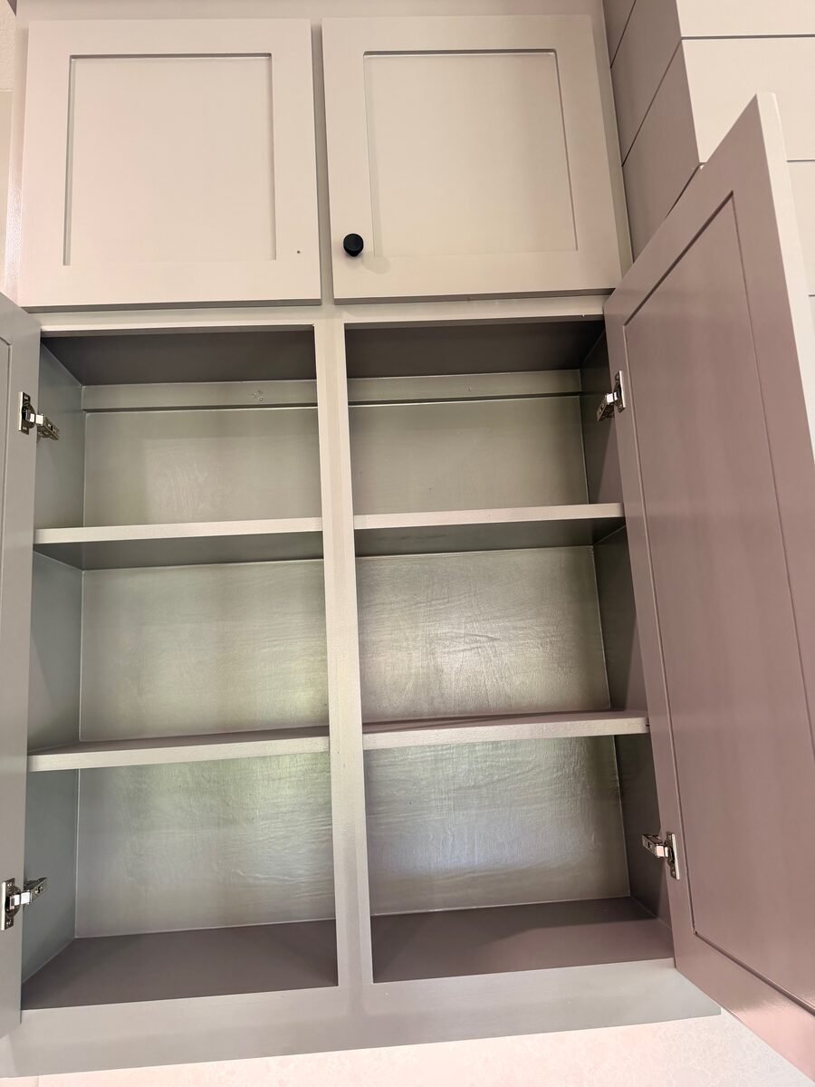 A kitchen cabinet emptied and the shelves wiped out