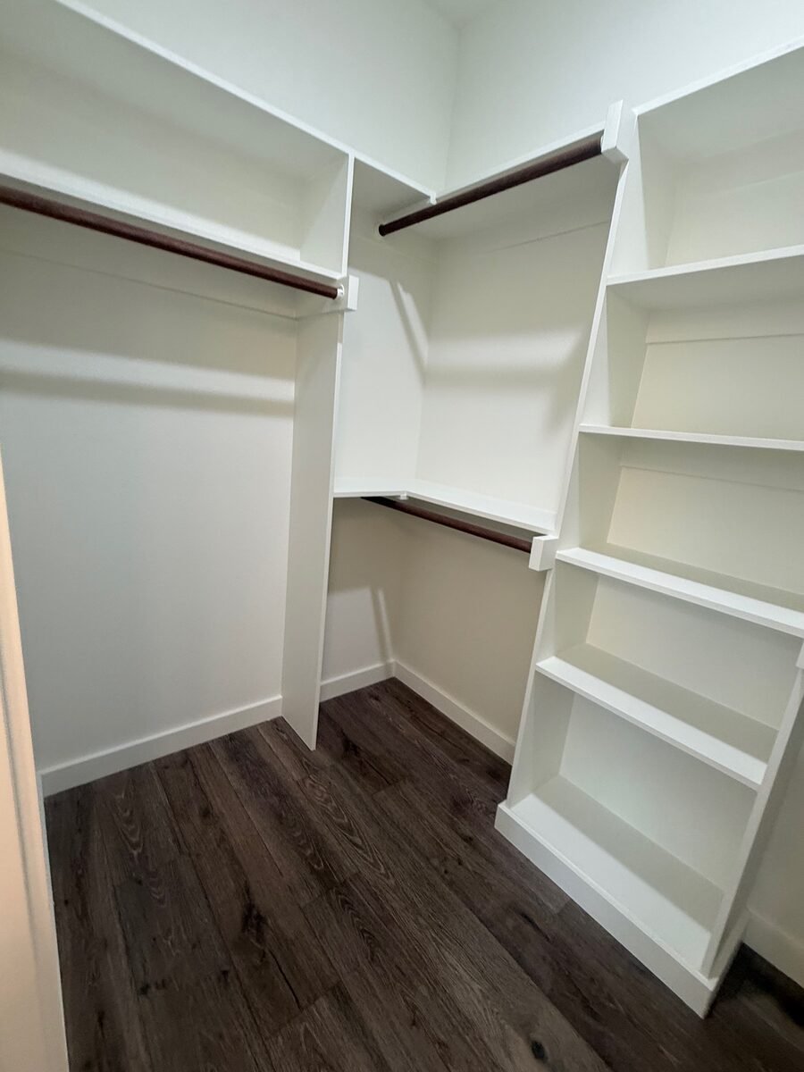 An empty walk-in closet with the shelving wiped down