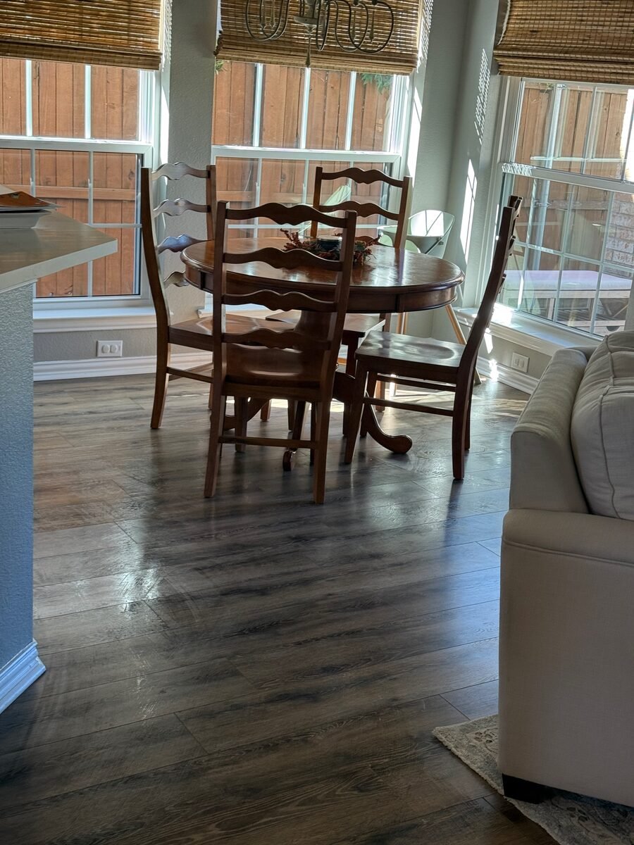 A dining table and chairs with the wood floor cleaned beneath them
