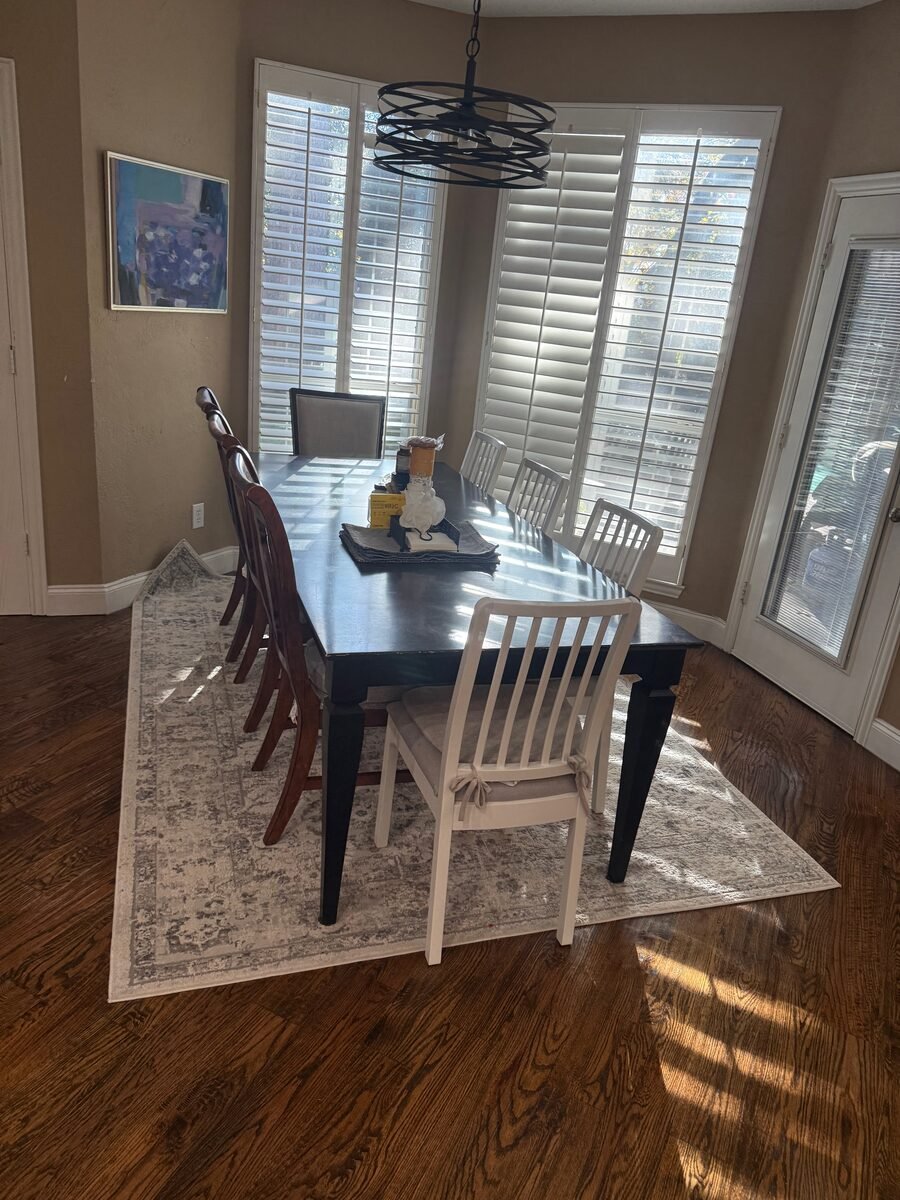 A dining table and chairs with the floor cleaned beneath them