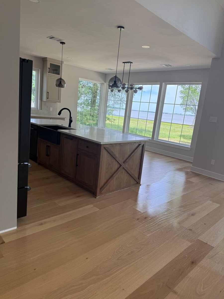 a kitchen island with pendant lights and a farmhouse sink in a Coppell home cleaned by SusyQ’s Cleaning