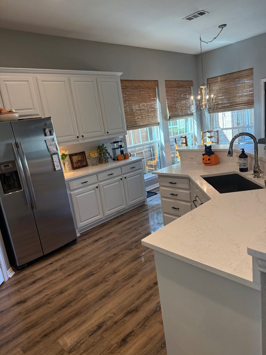 A white kitchen with the counters cleared and the island wiped down