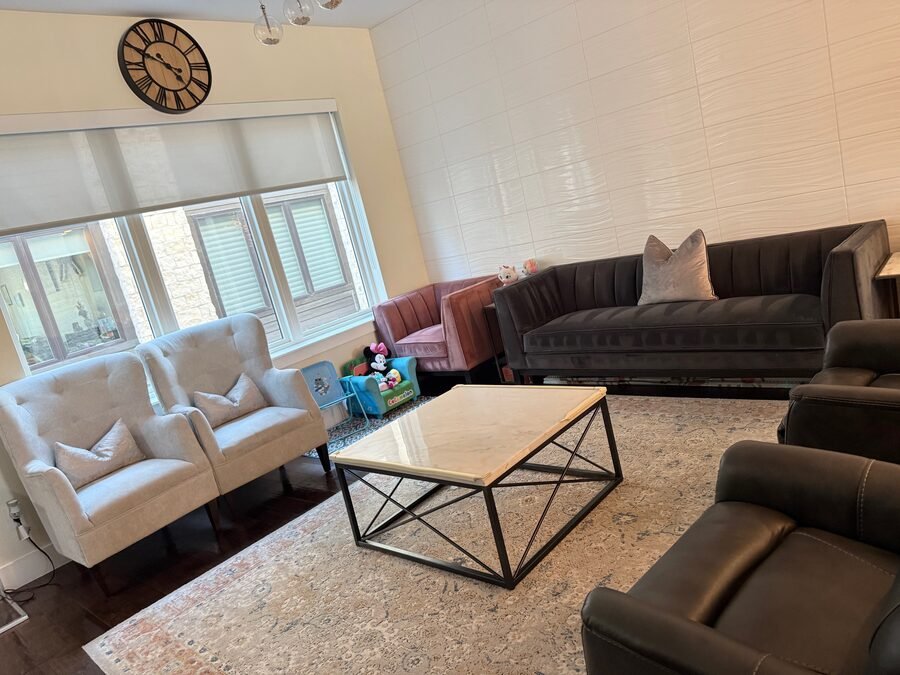 A living room with sofas, armchairs and a large rug, cleaned by SusyQ’s Cleaning